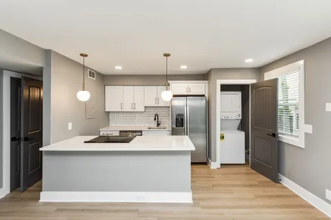 a kitchen with stainless steel appliances kitchen island granite countertop a refrigerator and a sink