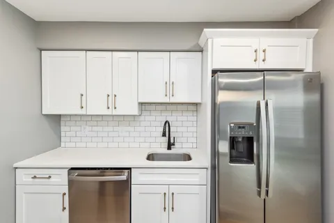 a kitchen with a refrigerator sink and cabinets