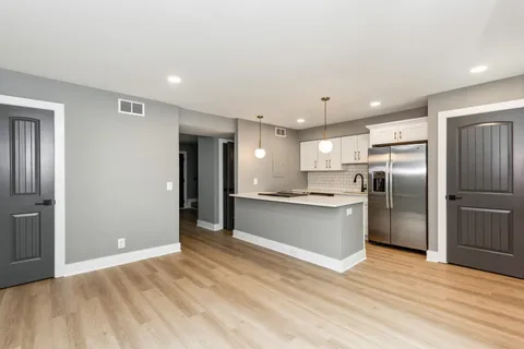 a large kitchen with a refrigerator and a sink