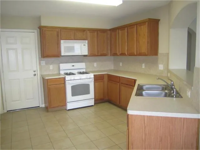 a kitchen with a stove sink and cabinets