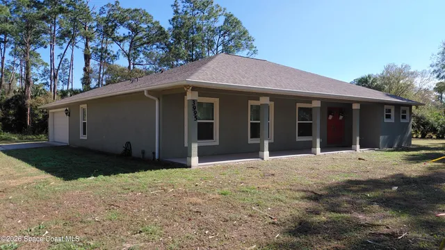 a front view of a house with a garden and yard