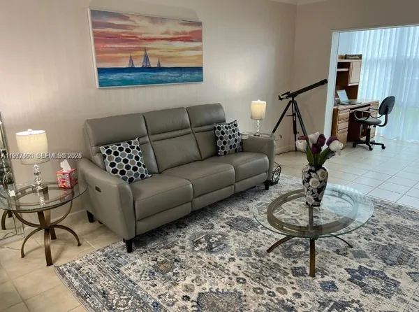 a living room with furniture a rug and a window