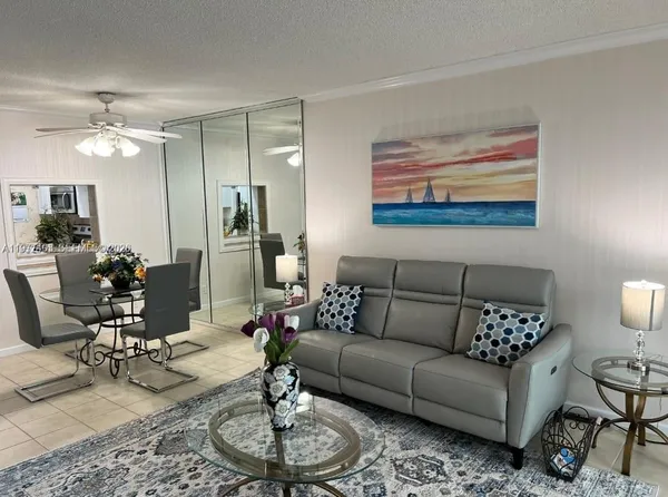 a living room with furniture a dining table and a chandelier