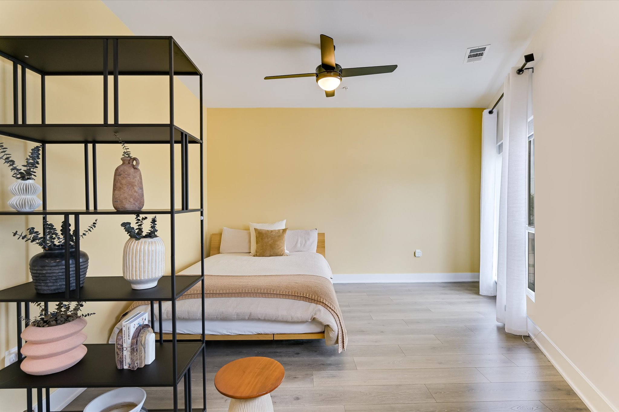 2220 Webberville Road, Unit 308 Austin, TX 78702 - Photo 9 of 21 Spacious room featuring wood-finish flooring, a contemporary ceiling fan, and large windows with white curtain rods