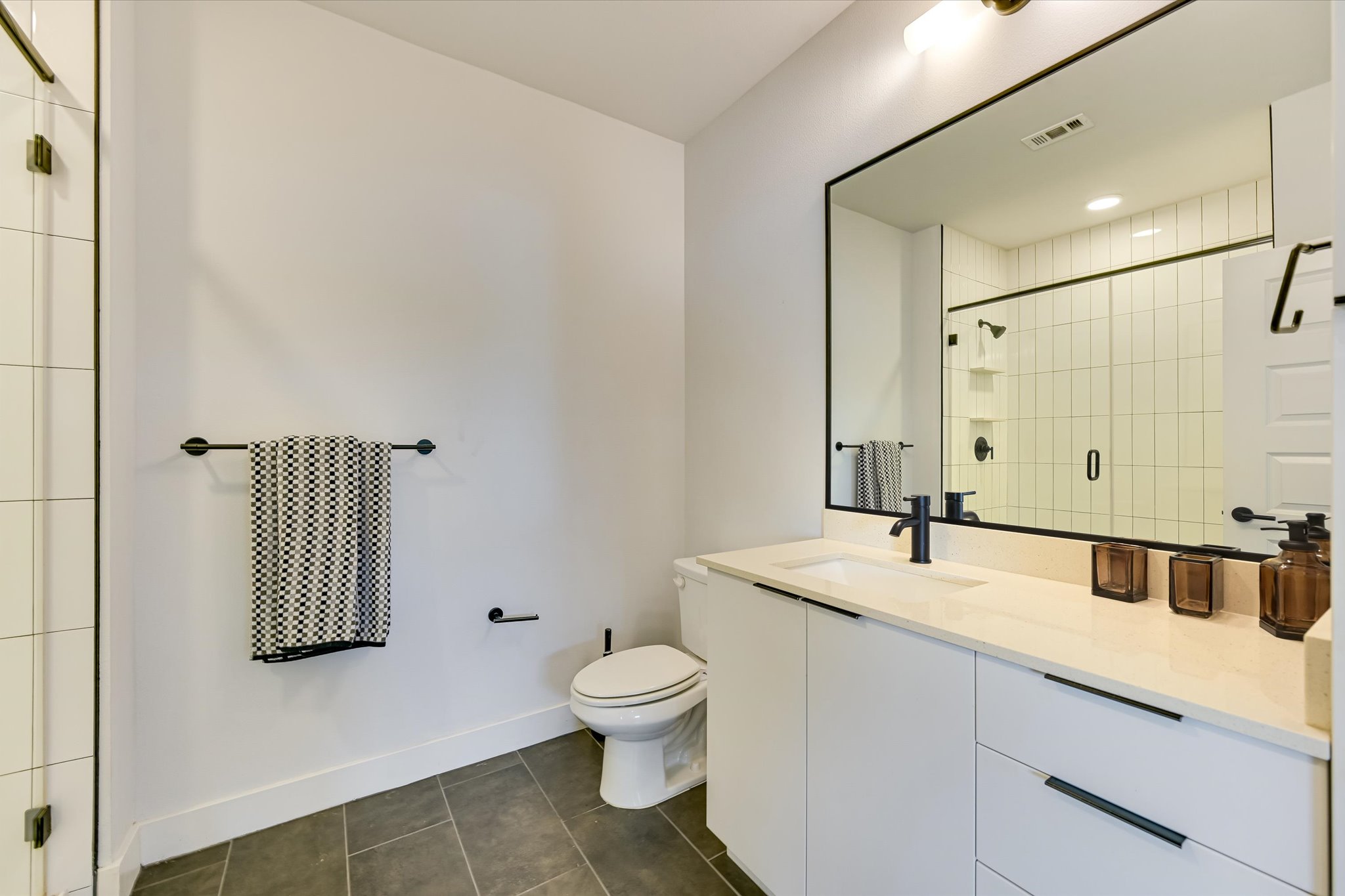 2220 Webberville Road, Unit 308 Austin, TX 78702 - Photo 10 of 21 Bathroom featuring a white vanity with integrated sink, light-toned countertop, and matte black hardware