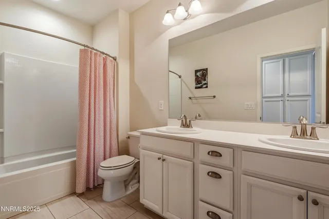 a bathroom with a sink a toilet and a large mirror