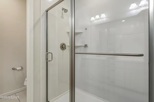 a bathroom with a shower and a glass door