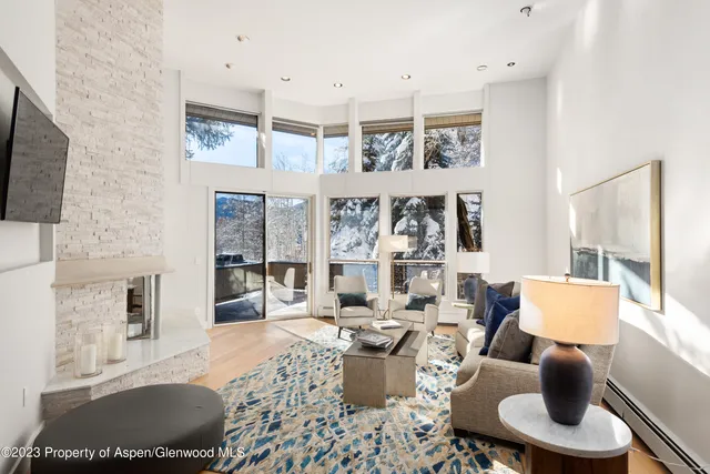 a living room with furniture a flat screen tv and a large window