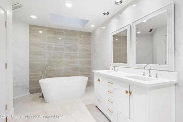 a bathroom with a bathtub a sink a toilet a mirror and vanity