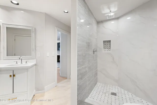 a bathroom with a sink a toilet a shower and a mirror