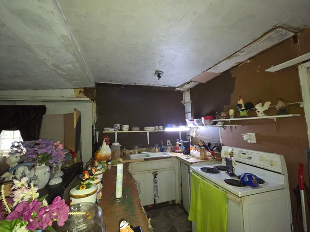 a kitchen with a stove and a wooden floor