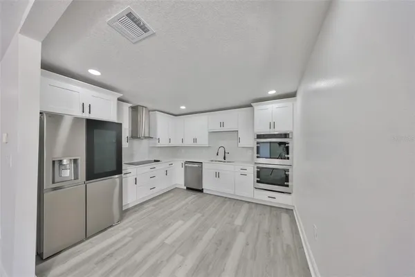 an empty room with wooden floor ceiling fan and window