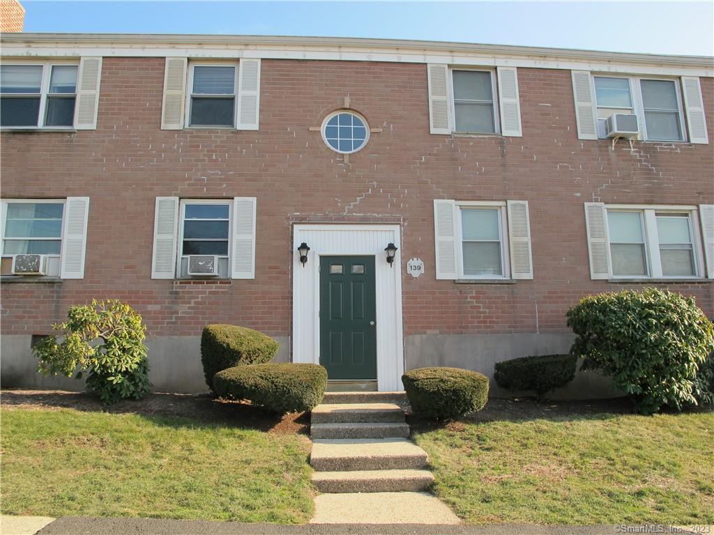 a view of a brick house with many windows and potted plants