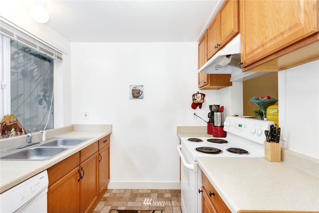 3935 Mason Loop Road Tacoma, WA 98409 - Photo 11 of 24 a kitchen with a sink a stove and a refrigerator