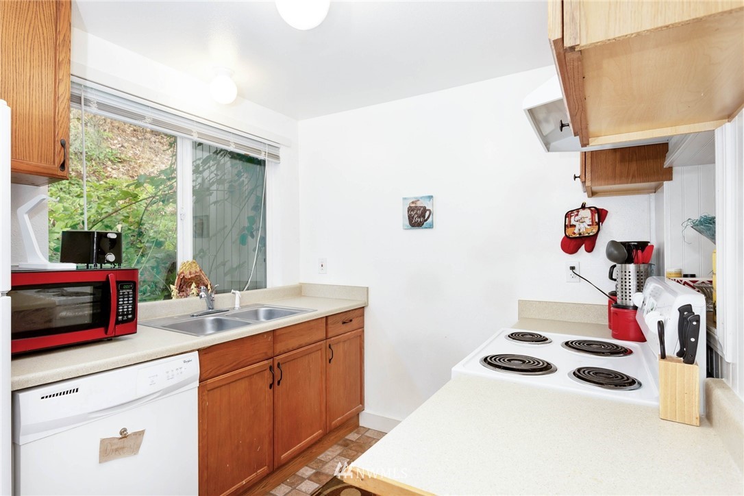 3935 Mason Loop Road Tacoma, WA 98409 - Photo 12 of 24 a kitchen with a sink a stove and cabinets