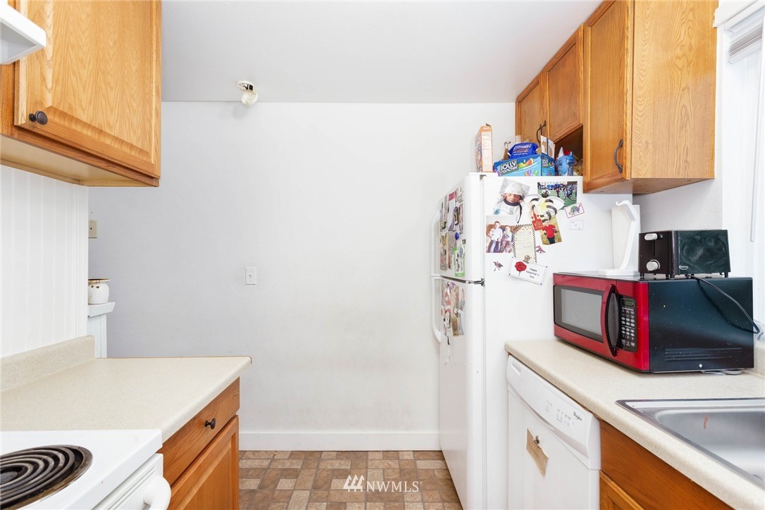 3935 Mason Loop Road Tacoma, WA 98409 - Photo 13 of 24 a kitchen with a refrigerator and a sink