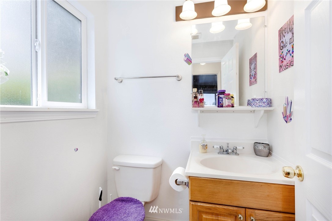 3935 Mason Loop Road Tacoma, WA 98409 - Photo 18 of 24 a bathroom with a sink vanity mirror and toilet
