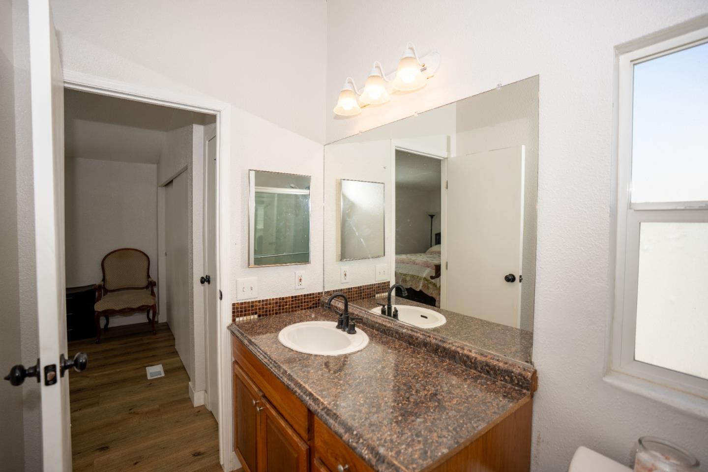 20 Russell Road, Unit 133 Salinas, CA 93906 - Photo 9 of 18 a bathroom with a granite countertop sink and a mirror