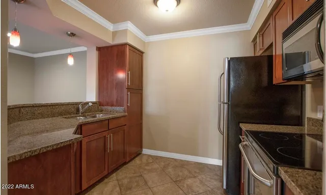 a kitchen with granite countertop a refrigerator and a sink