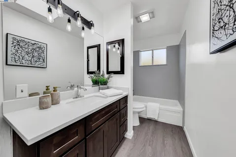 a bathroom with a sink a toilet and mirror