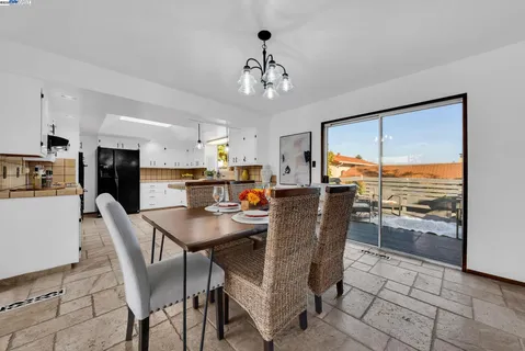 a dining room with furniture a chandelier and kitchen view