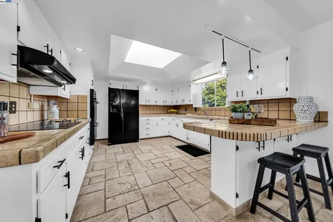 a kitchen with stainless steel appliances kitchen island granite countertop a refrigerator and a stove top oven