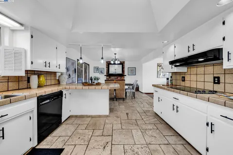 a kitchen with stainless steel appliances kitchen island granite countertop a sink and cabinets