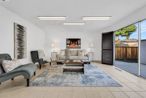 a living room with furniture and a floor to ceiling window