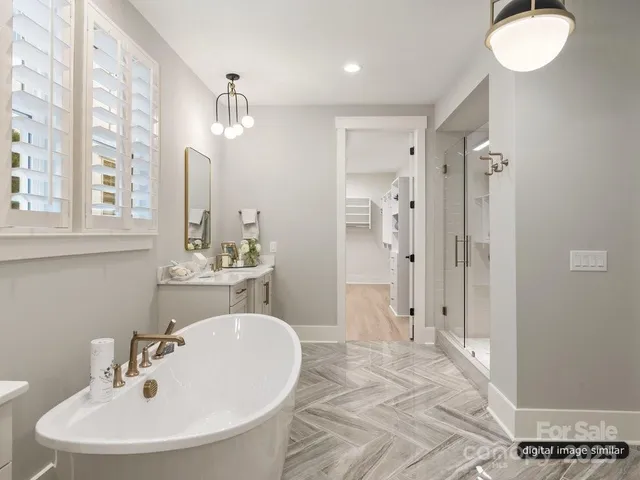 a bathroom with a sink a toilet a mirror and shower