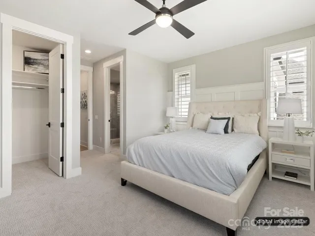 a spacious bedroom with a bed and ceiling fan