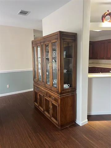 an empty room with wooden floor and entrance