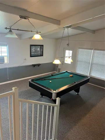 a room with pool table and windows