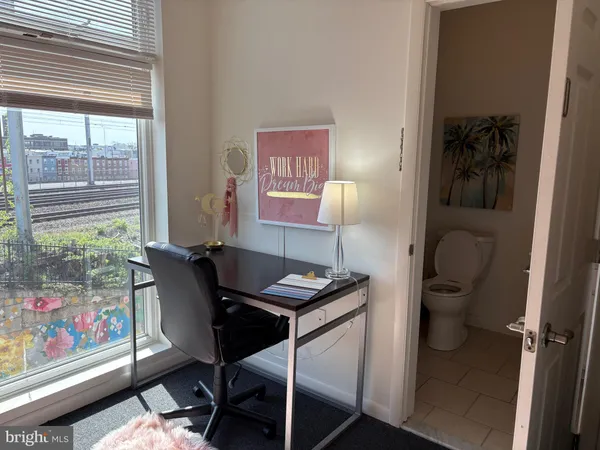 a view of a workspace with furniture and a window