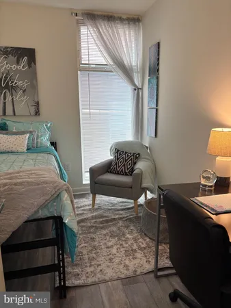 a bedroom with a bed and a dresser next to a window