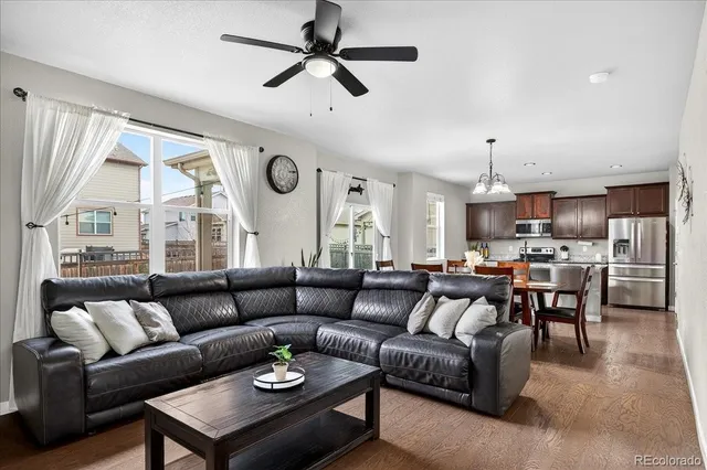 a living room with furniture kitchen view and a large window