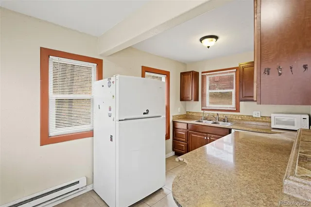 a kitchen with a refrigerator a stove a sink dishwasher and wooden cabinets