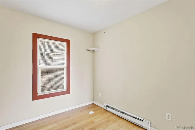 a view of a room with wooden floor and a window