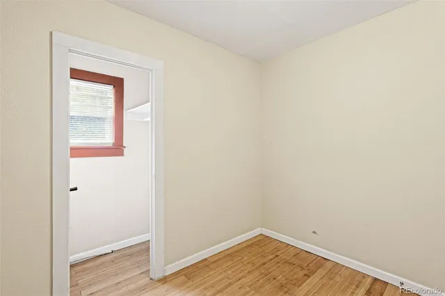 a view of a small space with wooden floor and a window