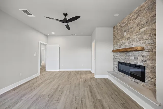 a view of wooden floor a fireplace and a chandelier in a room