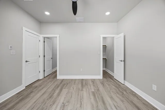 an empty room with wooden floor and entrance