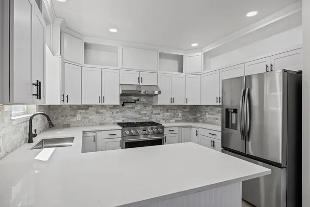 a kitchen with stainless steel appliances granite countertop a sink stove and refrigerator
