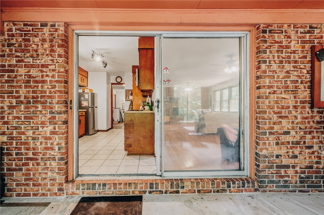 707 Campbell Town Road Walhalla, SC 29691 - Photo 22 of 44 Large brick-accented sliding glass doors open directly to the kitchen/living room space from the sunroom.