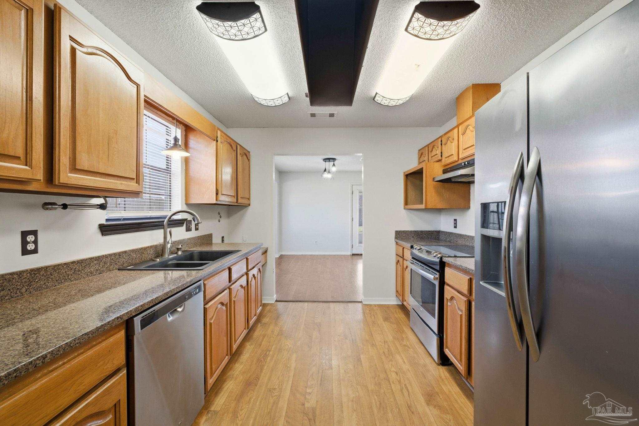 3228 Copper Ridge Circle Cantonment, FL 32533 - Photo 18 of 41 a kitchen with stainless steel appliances granite countertop a sink a stove and a refrigerator