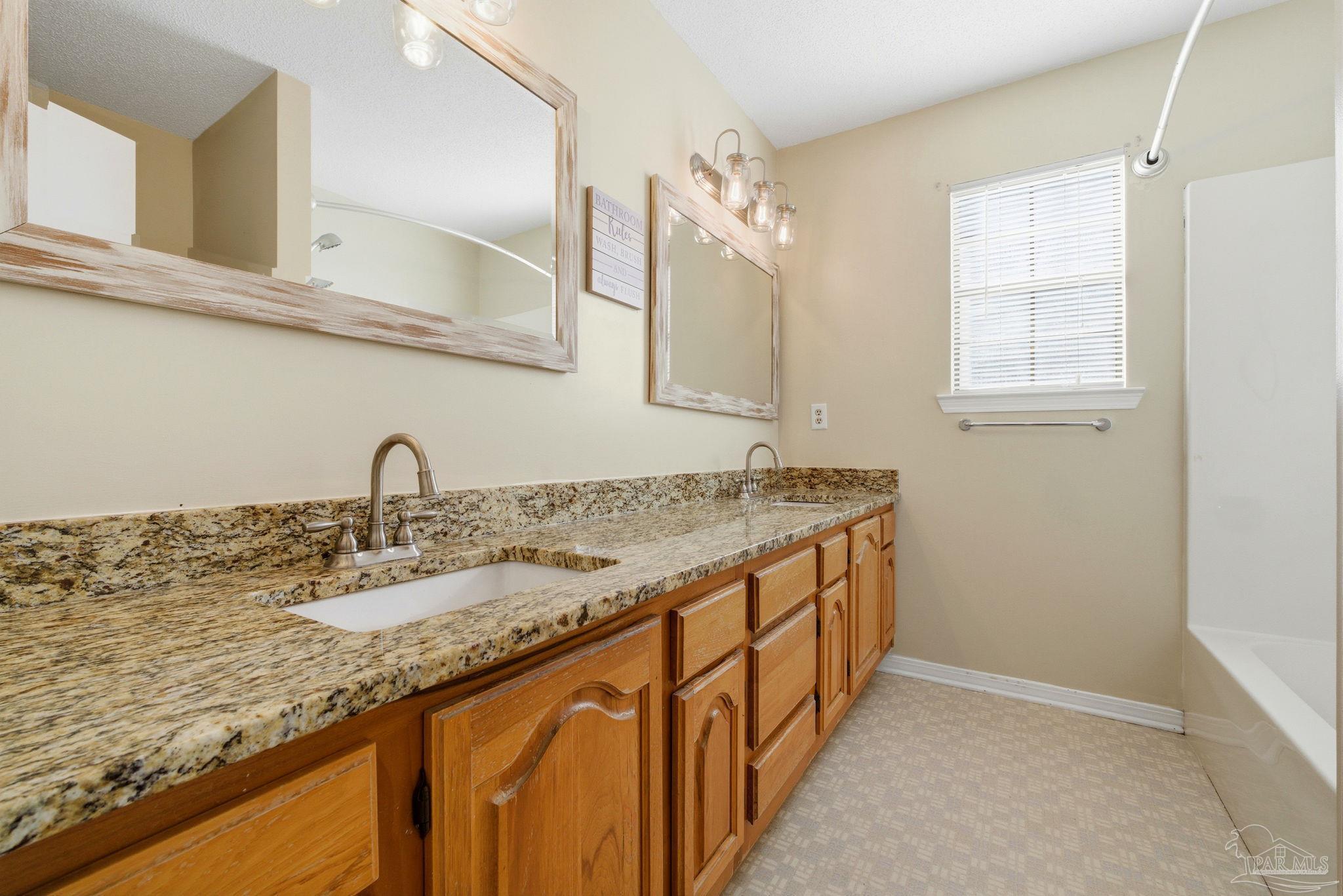 3228 Copper Ridge Circle Cantonment, FL 32533 - Photo 21 of 38 a bathroom with a granite countertop sink and a mirror