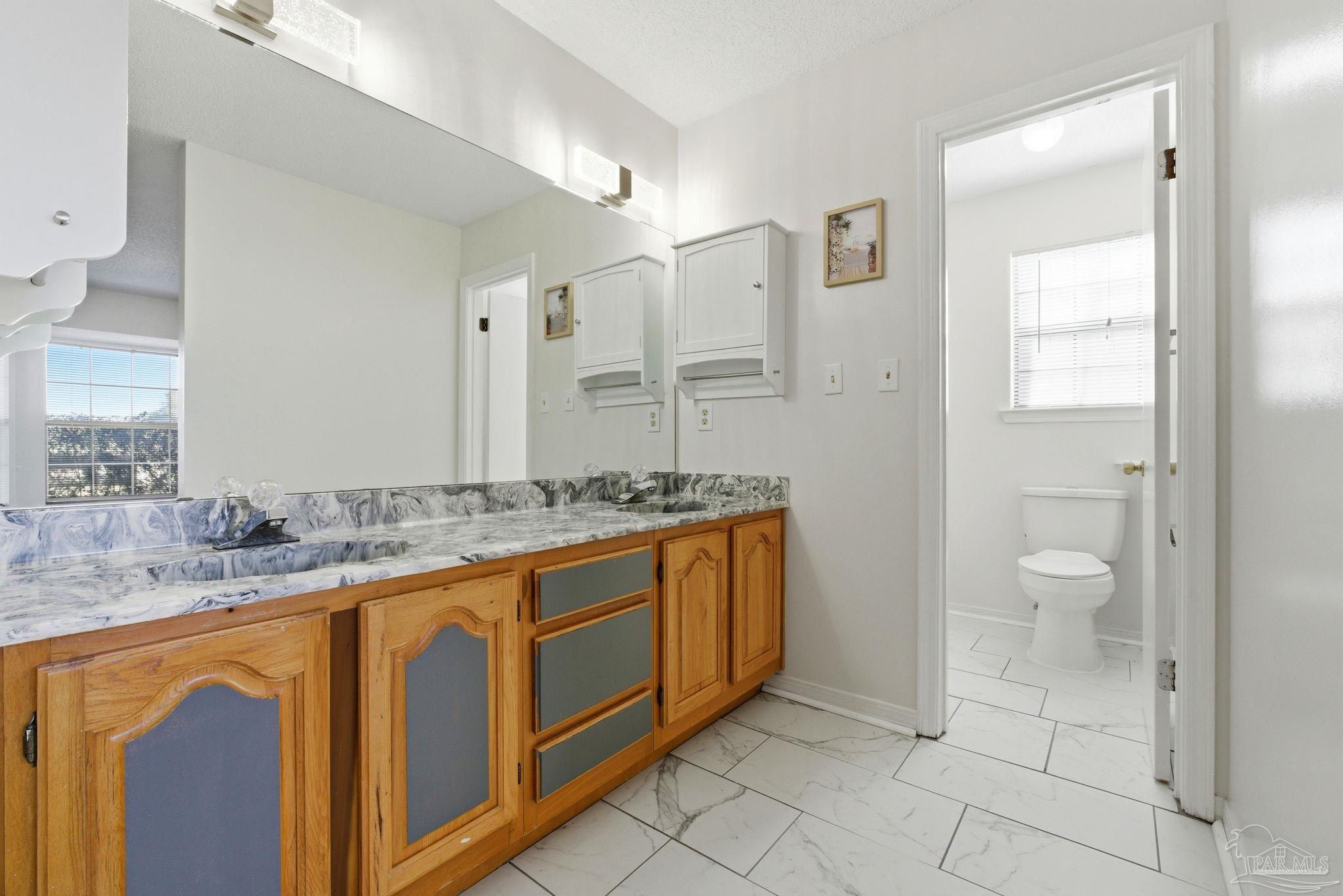 3228 Copper Ridge Circle Cantonment, FL 32533 - Photo 29 of 38 a bathroom with a granite countertop sink and a mirror