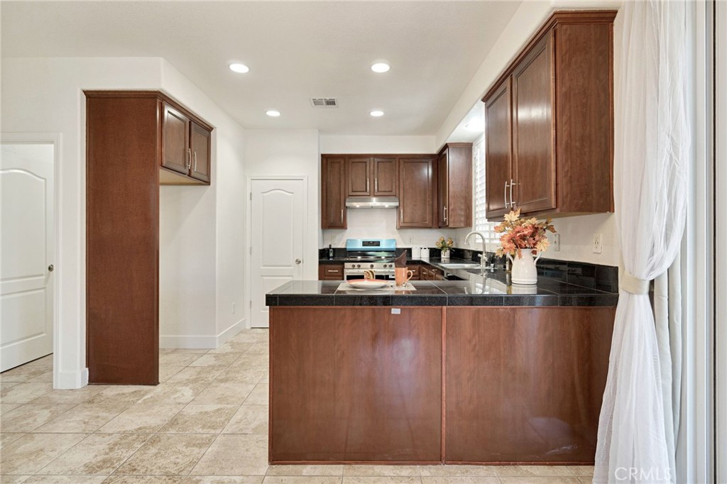 692 Blueberry Lane Madera, CA 93638 - Photo 13 of 44 a kitchen with stainless steel appliances granite countertop a sink a stove and a refrigerator