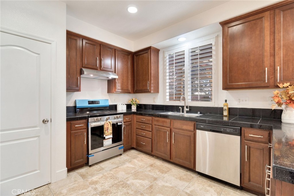 692 Blueberry Lane Madera, CA 93638 - Photo 14 of 44 a kitchen with stainless steel appliances granite countertop a stove sink and cabinets