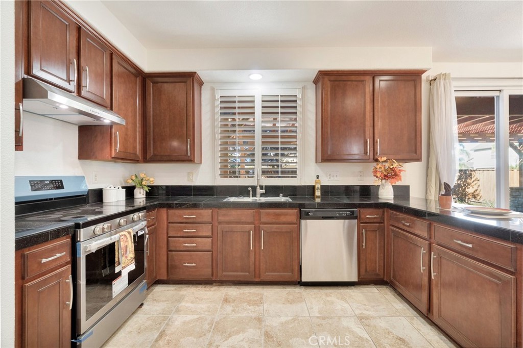 692 Blueberry Lane Madera, CA 93638 - Photo 15 of 44 a kitchen with stainless steel appliances granite countertop wooden cabinets a sink and a stove