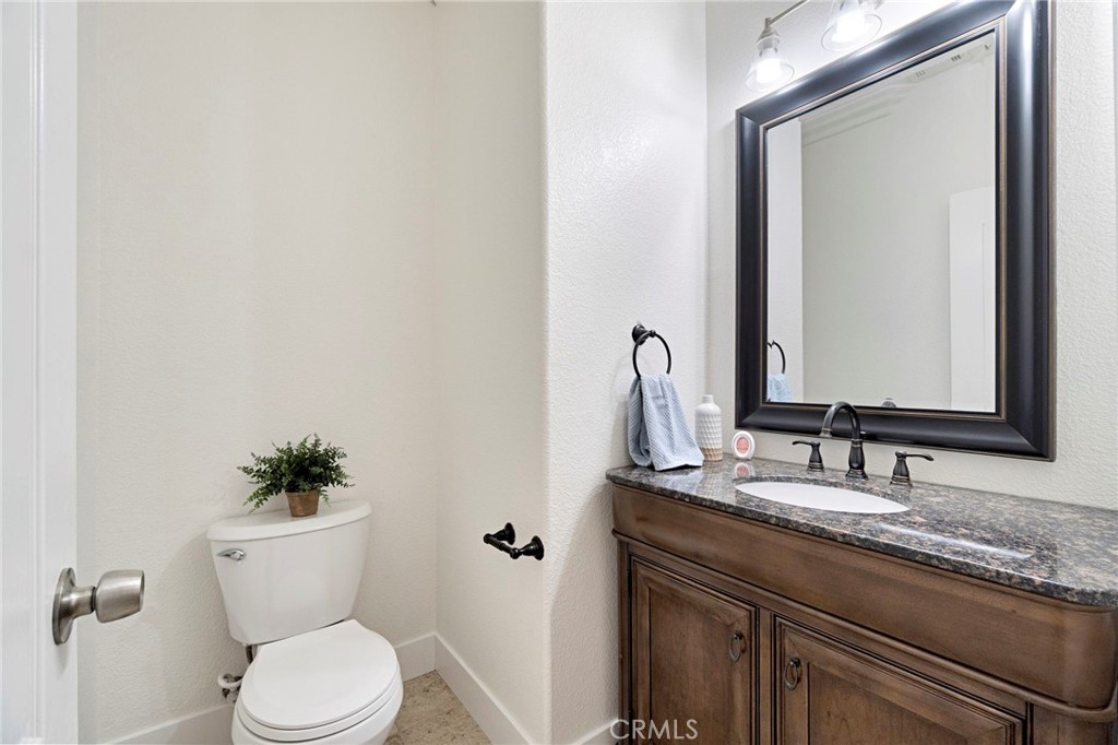 692 Blueberry Lane Madera, CA 93638 - Photo 17 of 44 a bathroom with a granite countertop sink vanity mirror and toilet