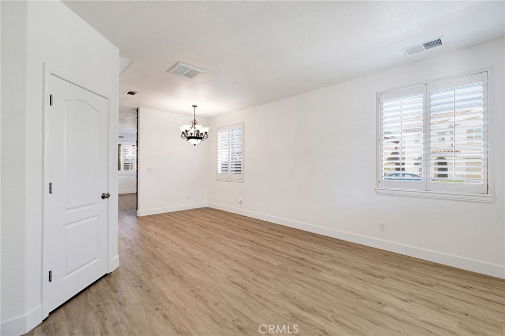 692 Blueberry Lane Madera, CA 93638 - Photo 3 of 44 an empty room with wooden floor cabinet and windows